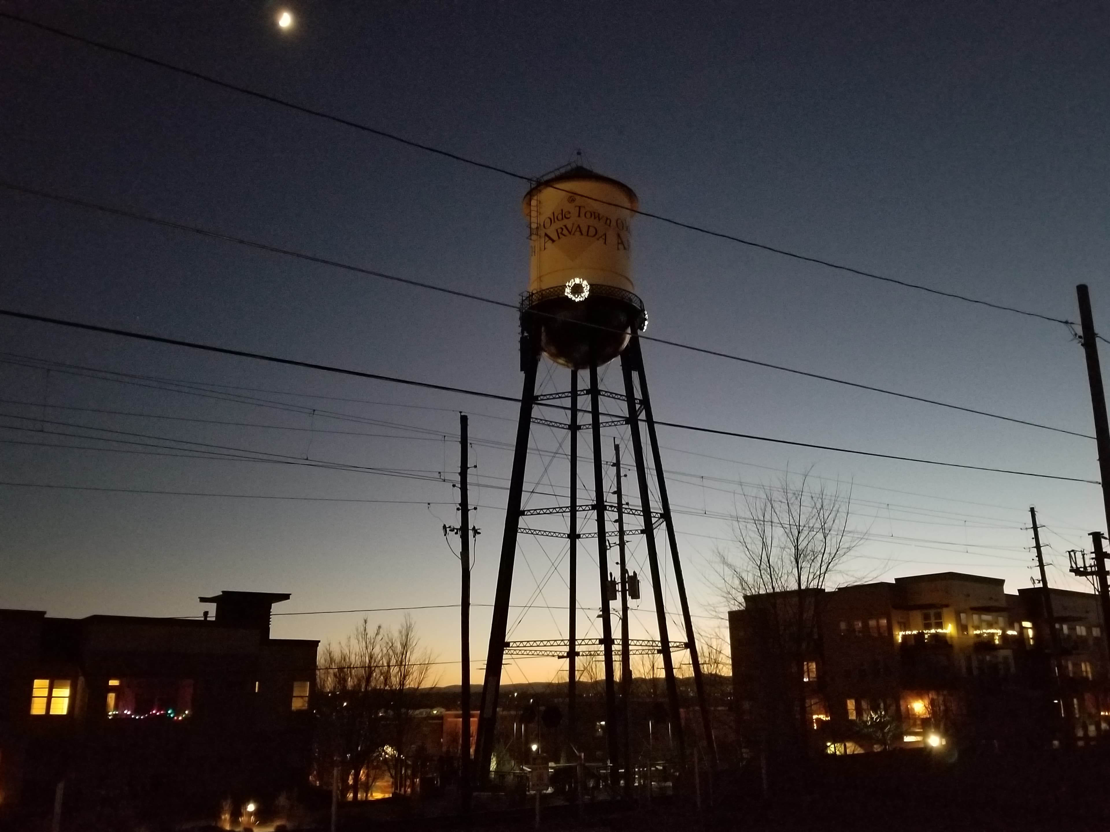 The Olde Town Arvada water tower at dusk, with a lit wreath